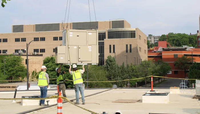 Contractors installing a rooftop unit. 