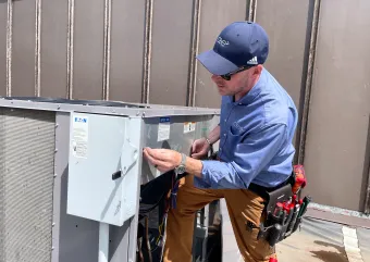 A HVAC technician performing maintenance on a commercial HVAC system. 