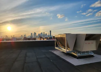 An image of HVAC equipment with the New York skyline in the horizon.  