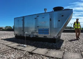 A contractor walking around a HVAC unit. 